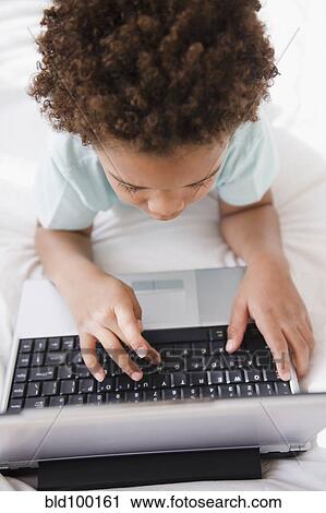 Stock Image - Black boy typing on computer. Fotosearch