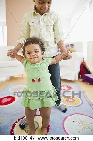 Black brother helping sister learn to walk View Large Photo Image Stock Photo - Black brother helping sister learn to walk. Fotosearch