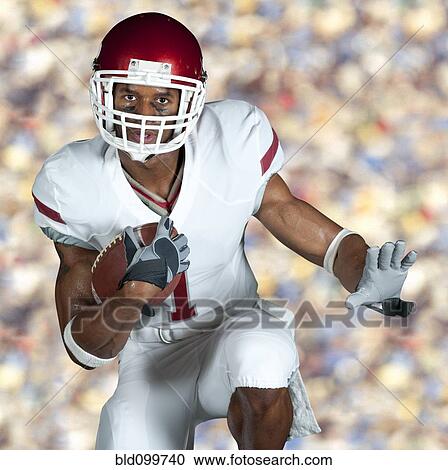 Stock Image - Black football player running with ball. Fotosearch