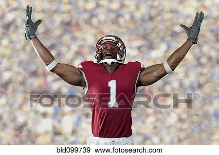 Black football player standing with arms raised View Large Photo Image Stock Photo - Black football player standing with arms raised. Fotosearch
