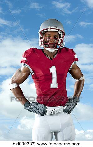 Stock Photo - Black football player with hands on hips. Fotosearch