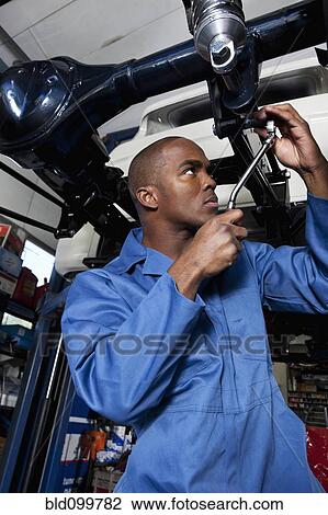 Black mechanic working on car View Large Photo Image Stock Image - Black mechanic working on car. Fotosearch