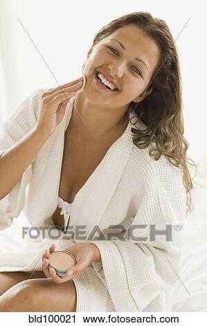 Stock Image - Brazilian woman putting on makeup. Fotosearch