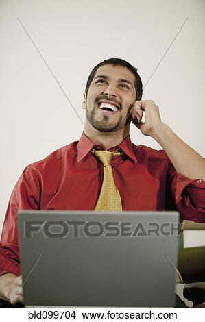 Businessman with laptop talking on cell phone View Large Photo Image Picture - Businessman with laptop talking on cell phone. Fotosearch