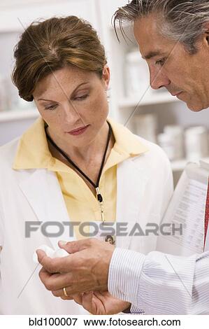 Caucasian co-workers working in pharmacy View Large Photo Image Stock Photo - Caucasian co-workers working in pharmacy. Fotosearch
