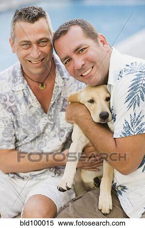 Stock Photography - Caucasian couple holding dog. Fotosearch