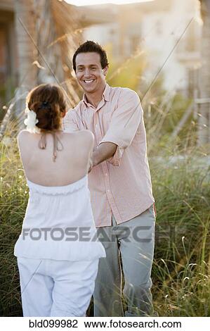 Stock Image - Caucasian couple holding hands outdoors. Fotosearch