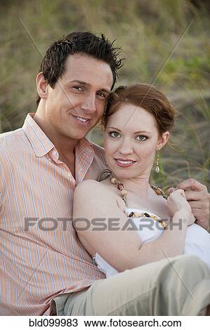 Stock Image - Caucasian couple sitting outdoors. Fotosearch