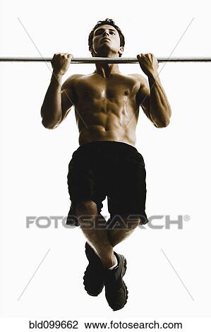 Stock Image - Caucasian man doing pull-ups. Fotosearch