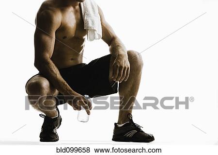 Stock Photo - Caucasian man drinking water after exercise. Fotosearch