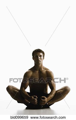 Caucasian man sitting on floor stretching View Large Photo Image Stock Photo - Caucasian man sitting on floor stretching. Fotosearch