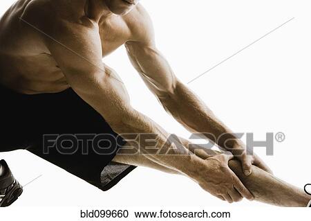 Stock Image - Caucasian man stretching before exercise. Fotosearch