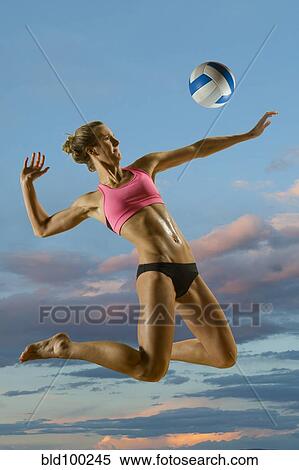 Stock Photography - Caucasian volleyball player hitting volleyball. Fotosearch