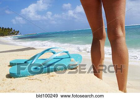 Stock Photo - Caucasian woman standing on beach. Fotosearch