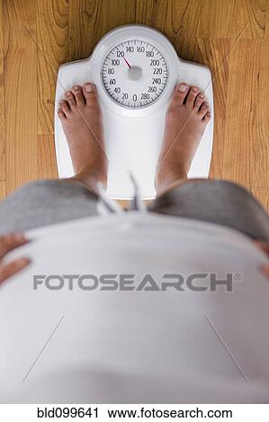 Caucasian woman standing on scale View Large Photo Image Stock Image - Caucasian woman standing on scale. Fotosearch