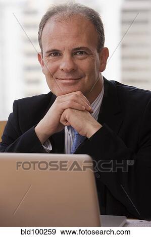 Chilean businessman sitting at desk View Large Photo Image Stock Photo - Chilean businessman sitting at desk. Fotosearch