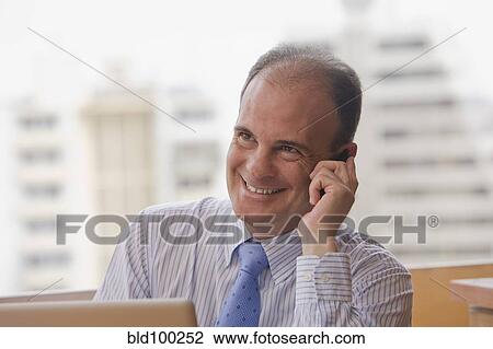 Chilean businessman talking on cell phone in office View Large Photo Image Stock Image - Chilean businessman talking on cell phone in office. Fotosearch