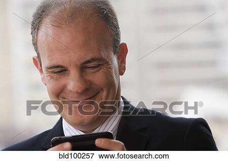 Chilean businessman text messaging on cell phone View Large Photo Image Stock Photo - Chilean businessman text messaging on cell phone. Fotosearch