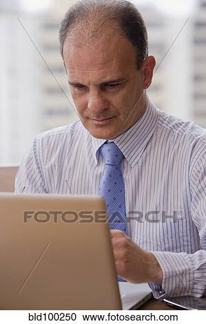 Chilean businessman using laptop at desk View Large Photo Image Stock Image - Chilean businessman using laptop at desk. Fotosearch