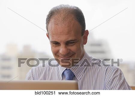 Chilean businessman using laptop at desk View Large Photo Image Stock Image - Chilean businessman using laptop at desk. Fotosearch