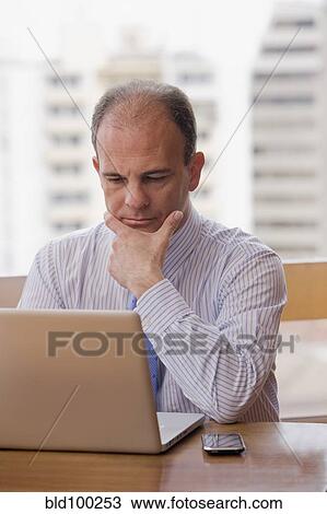 Chilean businessman using laptop at desk View Large Photo Image Stock Image - Chilean businessman using laptop at desk. Fotosearch