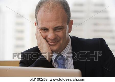 Chilean businessman using laptop in office View Large Photo Image Stock Photo - Chilean businessman using laptop in office. Fotosearch