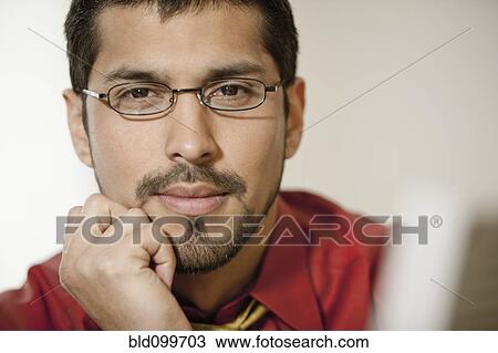 Stock Image - Close up of businessman with beard wearing eyeglasses. Fotosearch