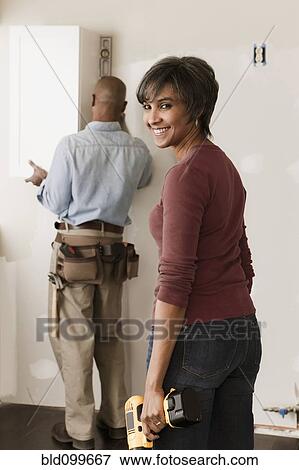 Stock Photo - Couple working in unfinished room. Fotosearch