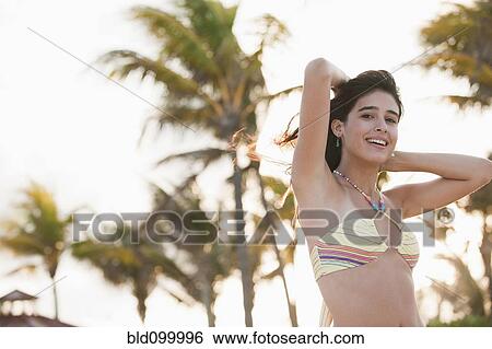 Stock Photograph - Cuban teenager in bikini standing on beach. Fotosearch