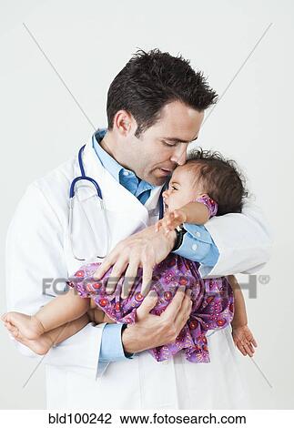 Doctor comforting baby girl View Large Photo Image Stock Image - Doctor comforting baby girl. Fotosearch