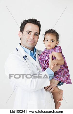 Stock Image - Doctor holding baby girl. Fotosearch