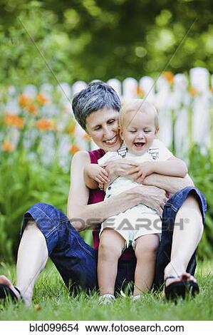 Grandmother hugging granddaughter in yard View Large Photo Image Picture - Grandmother hugging granddaughter in yard. Fotosearch