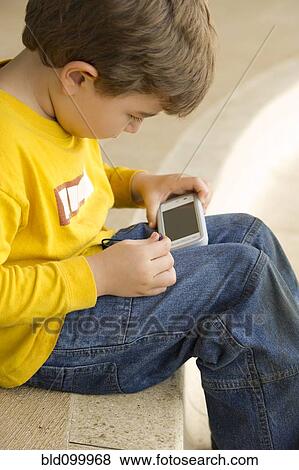 Stock Photo - Hispanic boy playing video game. Fotosearch