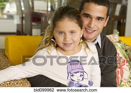 Hispanic girl sitting on father's lap View Large Photo Image Stock Image - Hispanic girl sitting on father's lap. Fotosearch