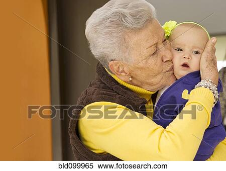 Stock Photography - Hispanic grandmother kissing baby granddaughter. Fotosearch