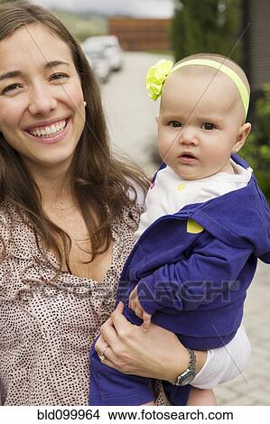 Picture - Hispanic mother holding baby daughter. Fotosearch