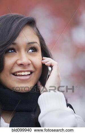Stock Image - Hispanic teenager talking on cell phone. Fotosearch