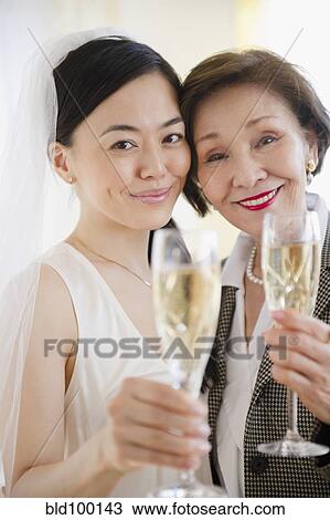 Stock Image - Japanese bride and mother drinking Champagne. Fotosearch