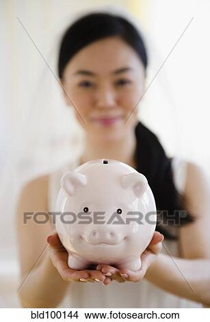 Picture - Japanese bride holding piggy bank. Fotosearch