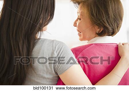 Stock Image - Japanese daughter hugging mother. Fotosearch