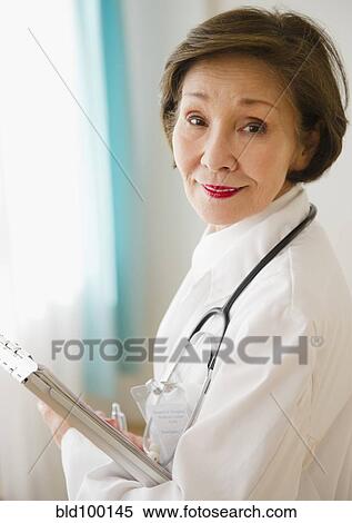 Stock Photography - Japanese doctor holding medical chart. Fotosearch
