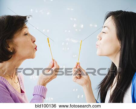 Japanese mother and daughter blowing bubbles View Large Photo Image Stock Photograph - Japanese mother and daughter blowing bubbles. Fotosearch