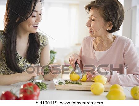 Stock Photo - Japanese mother and daughter cooking together. Fotosearch