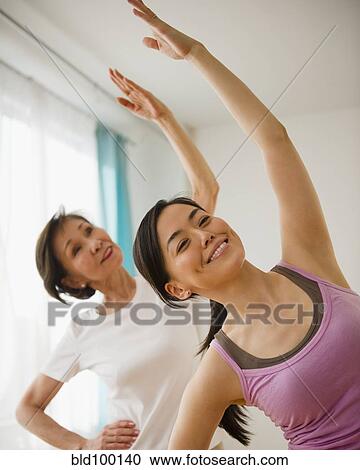 Stock Image - Japanese mother and daughter exercising together. Fotosearch
