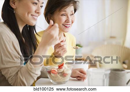 Stock Photography - Japanese mother and daughter having breakfast together. Fotosearch