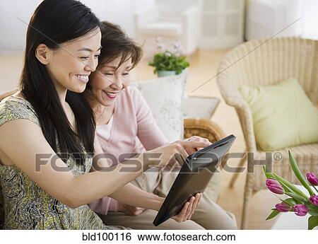 Stock Photograph - Japanese mother and daughter using digital tablet. Fotosearch
