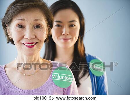 Stock Photography - Japanese mother and daughter wearing volunteer stickers. Fotosearch