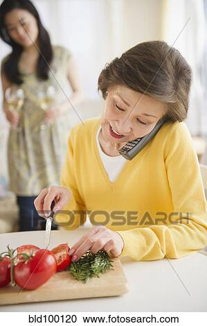 Japanese woman cutting vegetables and talking on telephone View Large Photo Image Stock Image - Japanese woman cutting vegetables and talking on telephone. Fotosearch