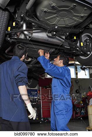 Stock Image - Mechanics working on car. Fotosearch