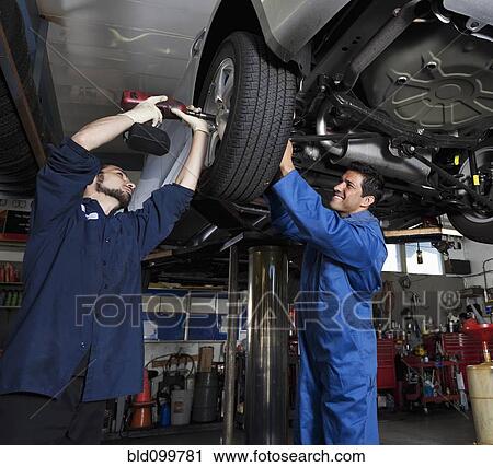 Stock Image - Mechanics working on car. Fotosearch